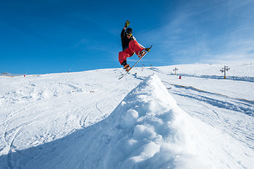 Image showing Snowboarder jumping against blue sky