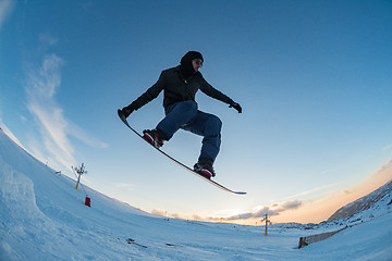 Image showing Snowboarder jumping against blue sky