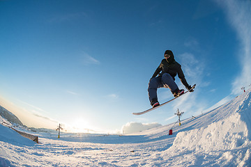 Image showing Snowboarder jumping against blue sky