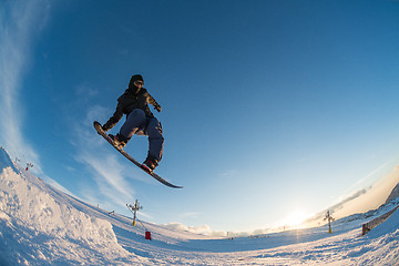 Image showing Snowboarder jumping against blue sky