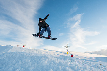 Image showing Snowboarder jumping against blue sky