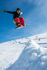 Image showing Snowboarder jumping against blue sky