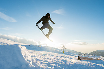 Image showing Snowboarder jumping against blue sky