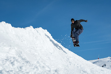 Image showing Snowboarder jumping against blue sky