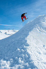 Image showing Snowboarder jumping against blue sky