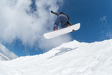 Image showing Snowboarder jumping against blue sky