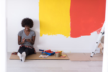 Image showing back female painter sitting on floor