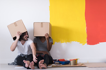 Image showing young multiethnic couple playing with cardboard boxes