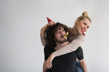 Image showing couple in party hats blowing in whistle