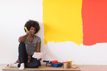 Image showing back female painter sitting on floor