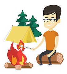 Image showing Woman roasting marshmallow over campfire.