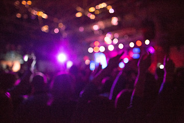 Image showing The silhouettes of concert crowd in front of bright stage lights