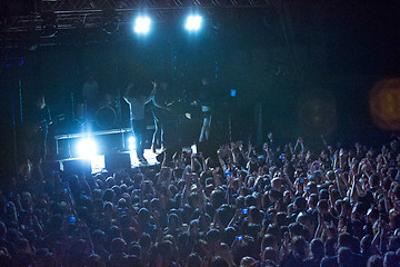 Image showing The silhouettes of concert crowd in front of bright stage lights