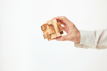 Image showing Man\'s hands holding wooden puzzle.