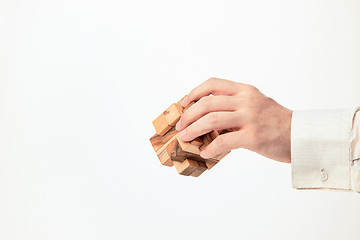 Image showing Man\'s hands holding wooden puzzle.