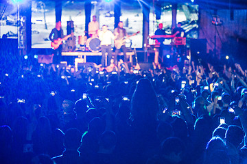 Image showing The silhouettes of concert crowd in front of bright stage lights