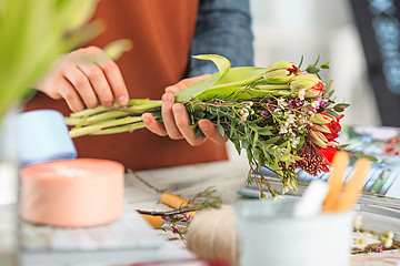 Image showing Florist at work: the female hands of woman making fashion modern bouquet of different flowers