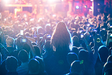 Image showing The silhouettes of concert crowd in front of bright stage lights