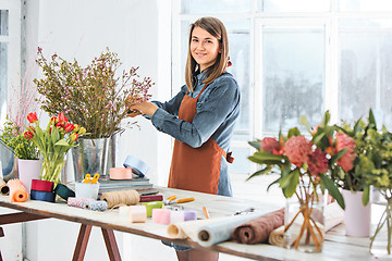 Image showing Florist at work: the young girl making fashion modern bouquet of different flowers