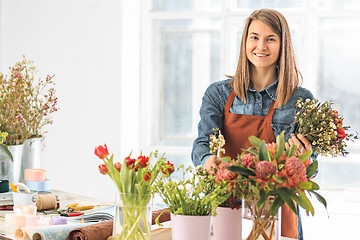 Image showing Florist at work: the young girl making fashion modern bouquet of different flowers