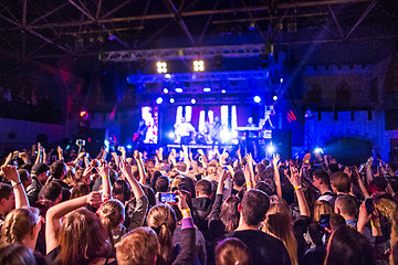 Image showing The silhouettes of concert crowd in front of bright stage lights