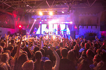 Image showing The silhouettes of concert crowd in front of bright stage lights