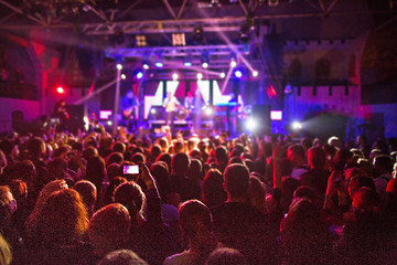 Image showing The silhouettes of concert crowd in front of bright stage lights