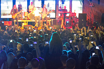 Image showing The silhouettes of concert crowd in front of bright stage lights