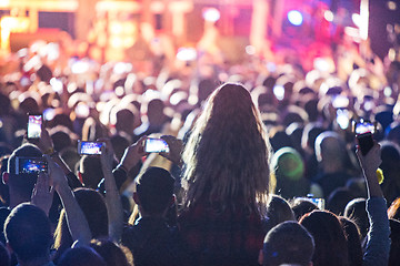 Image showing The silhouettes of concert crowd in front of bright stage lights