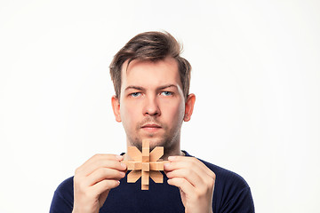 Image showing Attractive 25 year old business man looking confused with wooden puzzle.