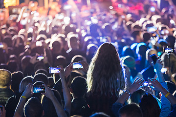 Image showing The silhouettes of concert crowd in front of bright stage lights