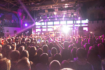 Image showing The silhouettes of concert crowd in front of bright stage lights