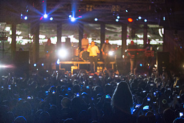 Image showing The silhouettes of concert crowd in front of bright stage lights