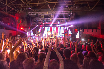 Image showing The silhouettes of concert crowd in front of bright stage lights