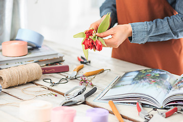 Image showing Florist at work: the female hands of woman making fashion modern bouquet of different flowers