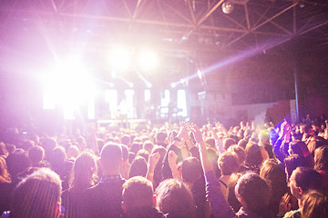 Image showing The silhouettes of concert crowd in front of bright stage lights