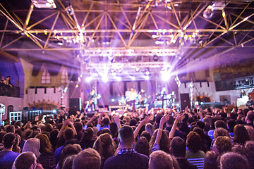 Image showing The silhouettes of concert crowd in front of bright stage lights