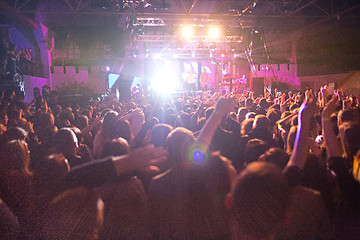 Image showing The silhouettes of concert crowd in front of bright stage lights