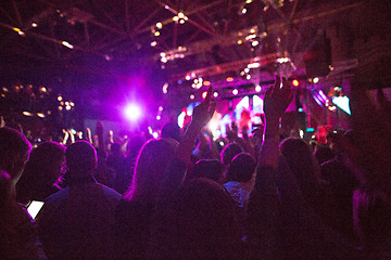 Image showing The silhouettes of concert crowd in front of bright stage lights