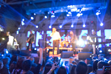 Image showing The silhouettes of concert crowd in front of bright stage lights