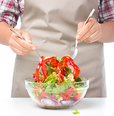 Image showing Cook is mixing salad