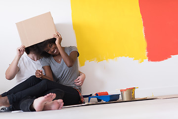 Image showing young multiethnic couple playing with cardboard boxes