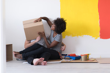 Image showing young multiethnic couple playing with cardboard boxes