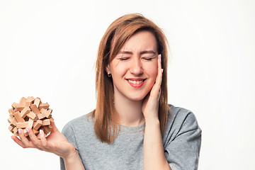 Image showing Attractive 24 year old business woman looking confused with wooden puzzle.