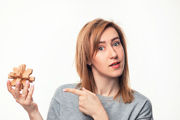 Image showing Attractive 24 year old business woman looking confused with wooden puzzle.