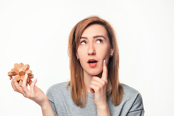 Image showing Attractive 24 year old business woman looking confused with wooden puzzle.