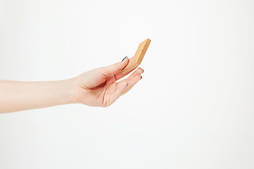 Image showing The toy wooden puzzle in hand isolated on white background