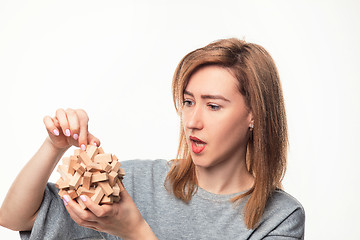 Image showing Attractive 24 year old business woman looking confused with wooden puzzle.