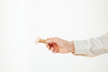 Image showing The toy wooden puzzle in hand isolated on white background