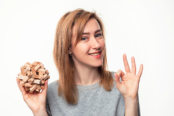 Image showing Attractive 24 year old business woman looking confused with wooden puzzle.